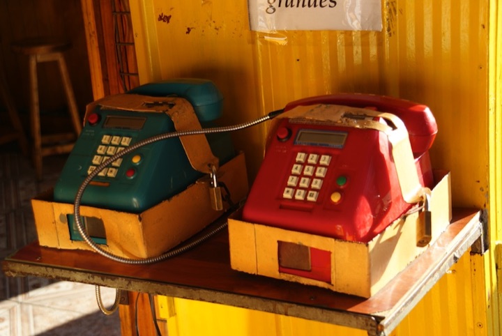 Two public telephones secured with chains and padlocks.