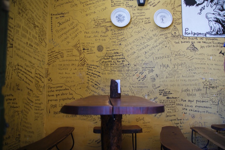 Restaurant dining room with walls covered in handwritten customer comments.