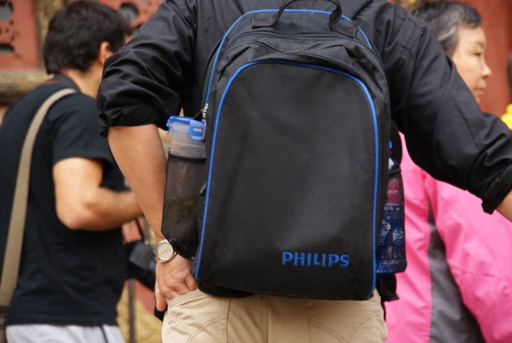 Black Philips backpack worn by a person in a crowd.